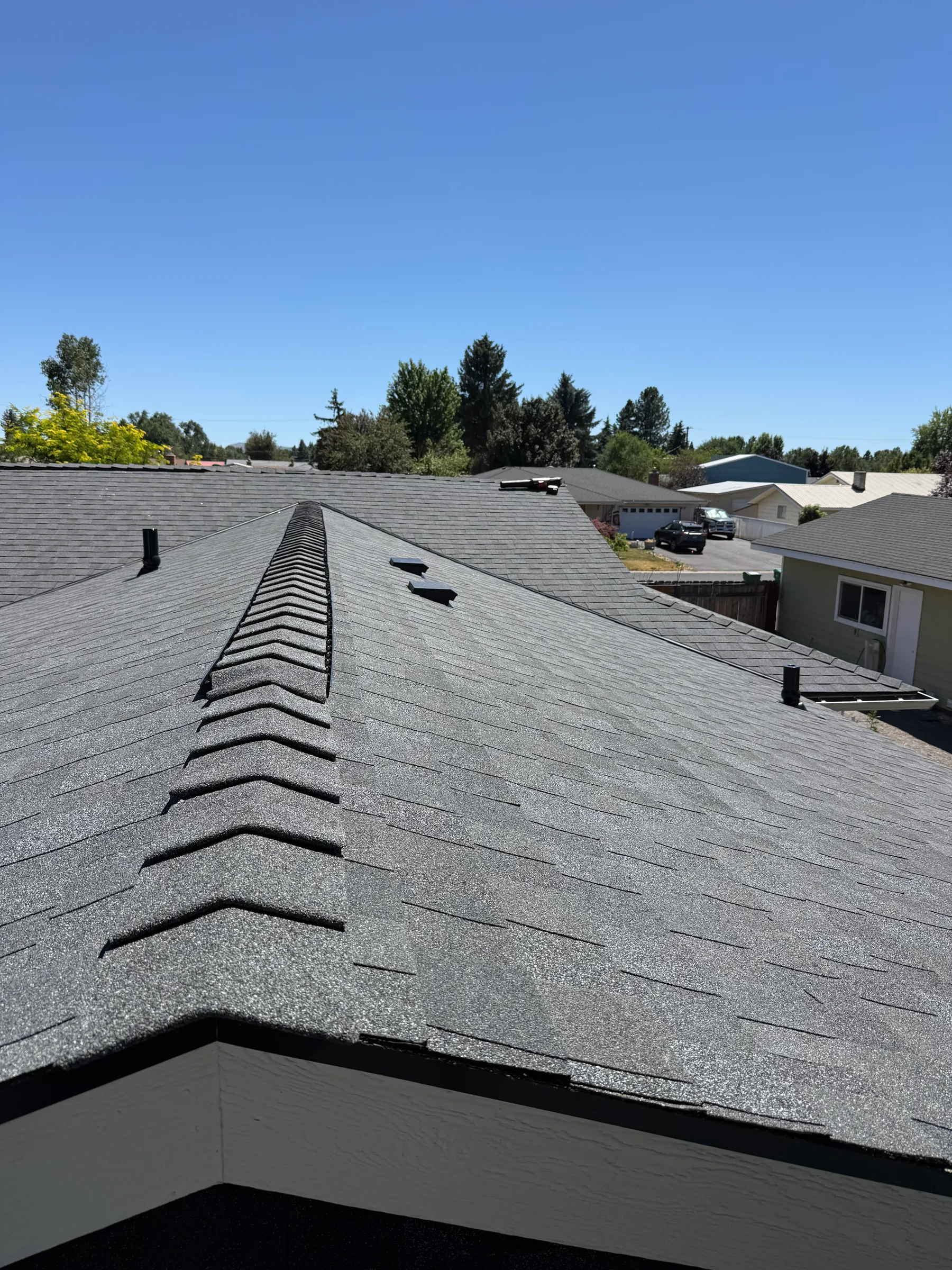 Finished gray shingle roof with a white gable edge