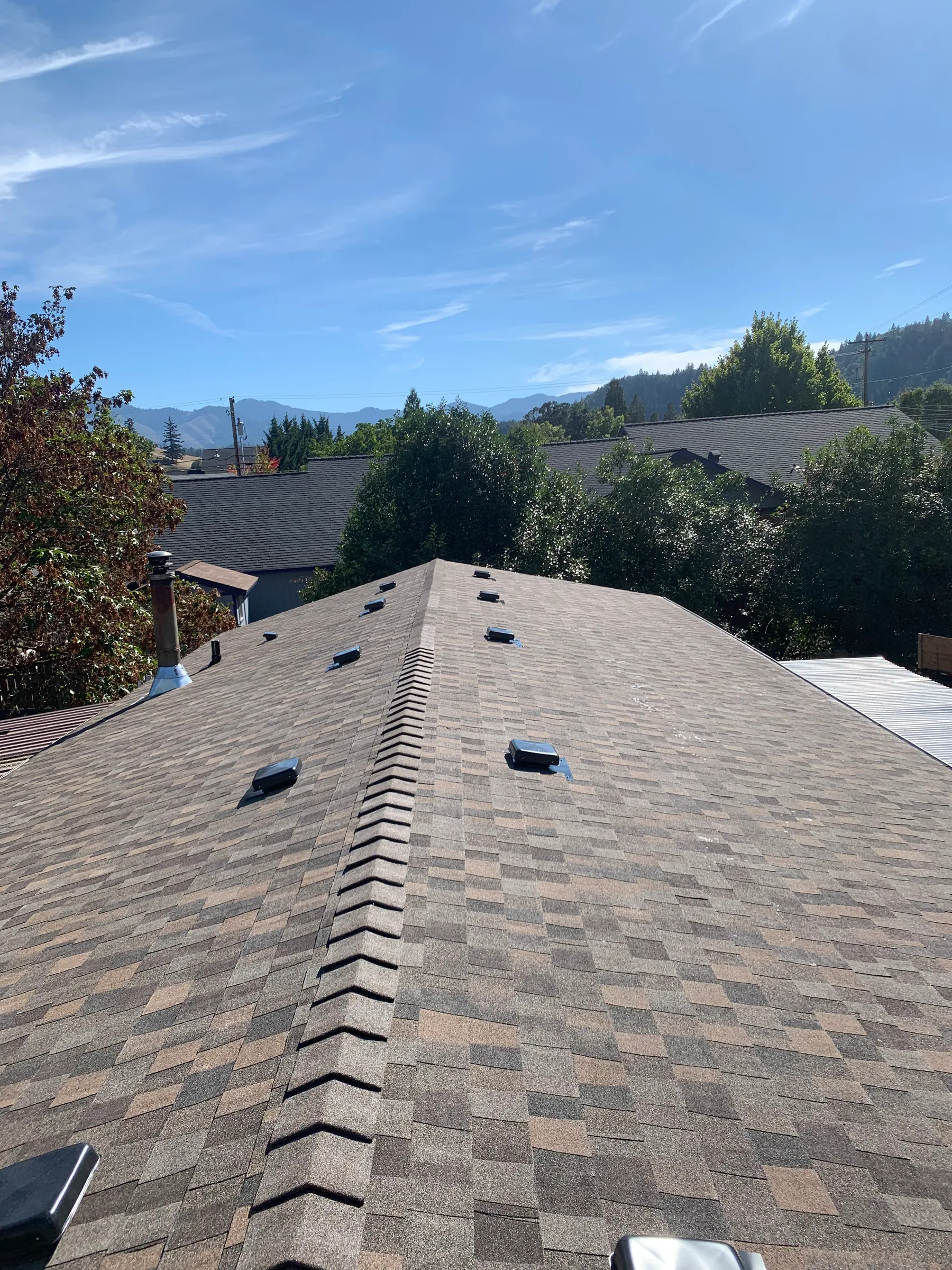 Completed shingle roof with ridge caps and roof vents