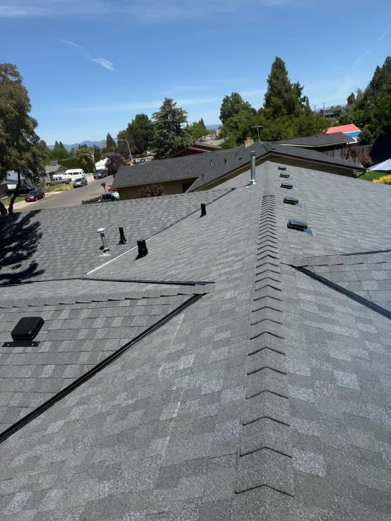 Finished residential roof with intersecting shingle roof planes