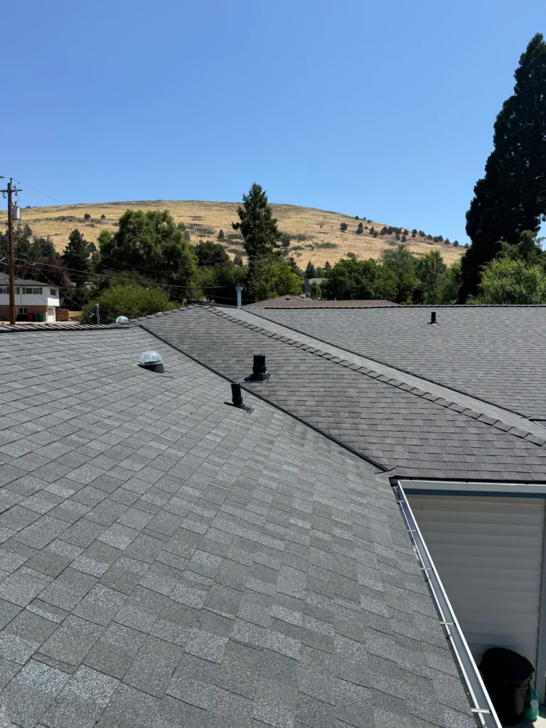 Residential shingle roof with a dry hillside beyond