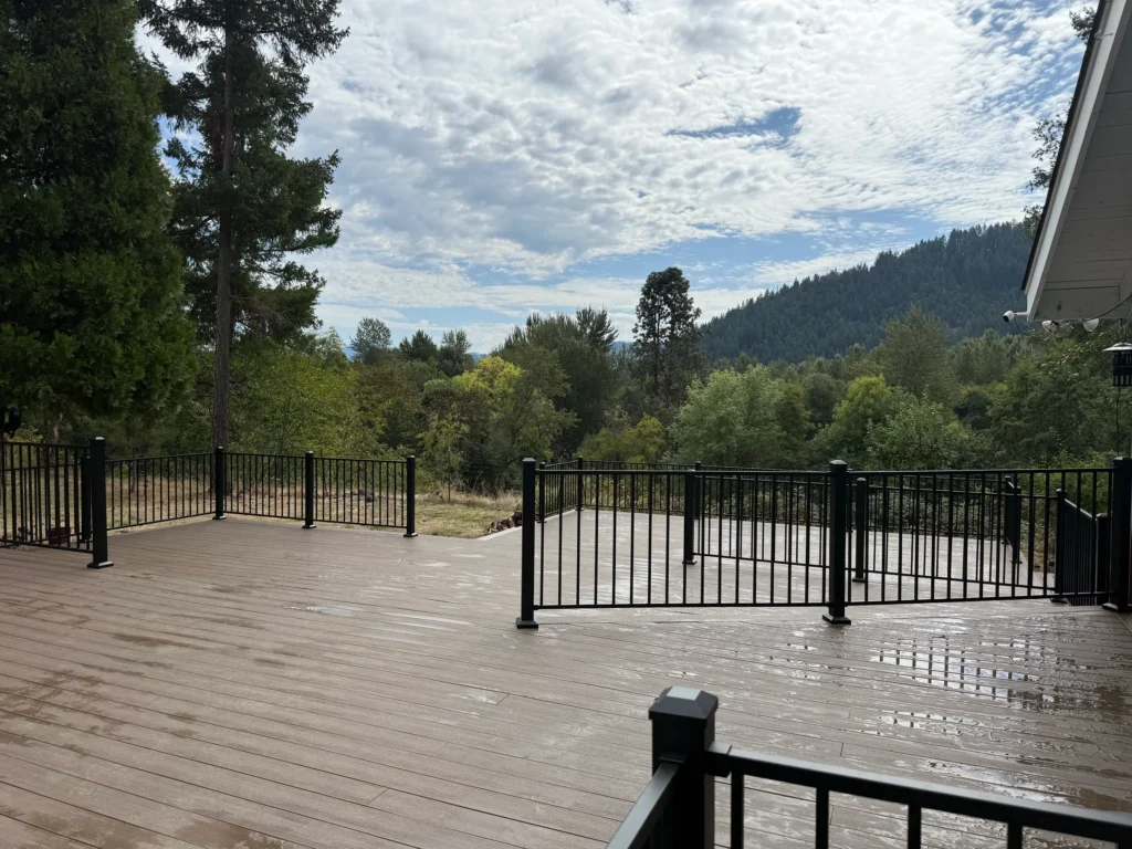 Finished deck with dark railings and a wooded outlook