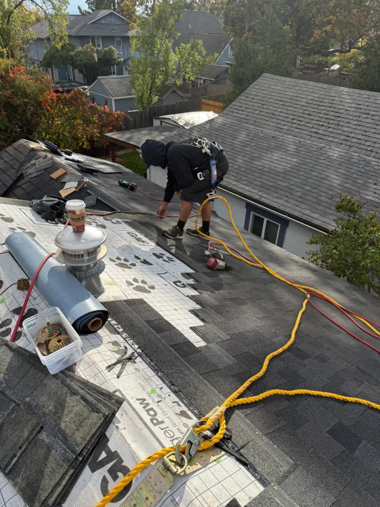 Roofer installing shingles on a residential roof